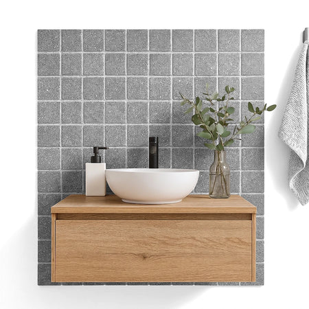 Stylish bathroom vanity with a round white sink, black faucet, and light wood cabinet, complemented by textured grey wall