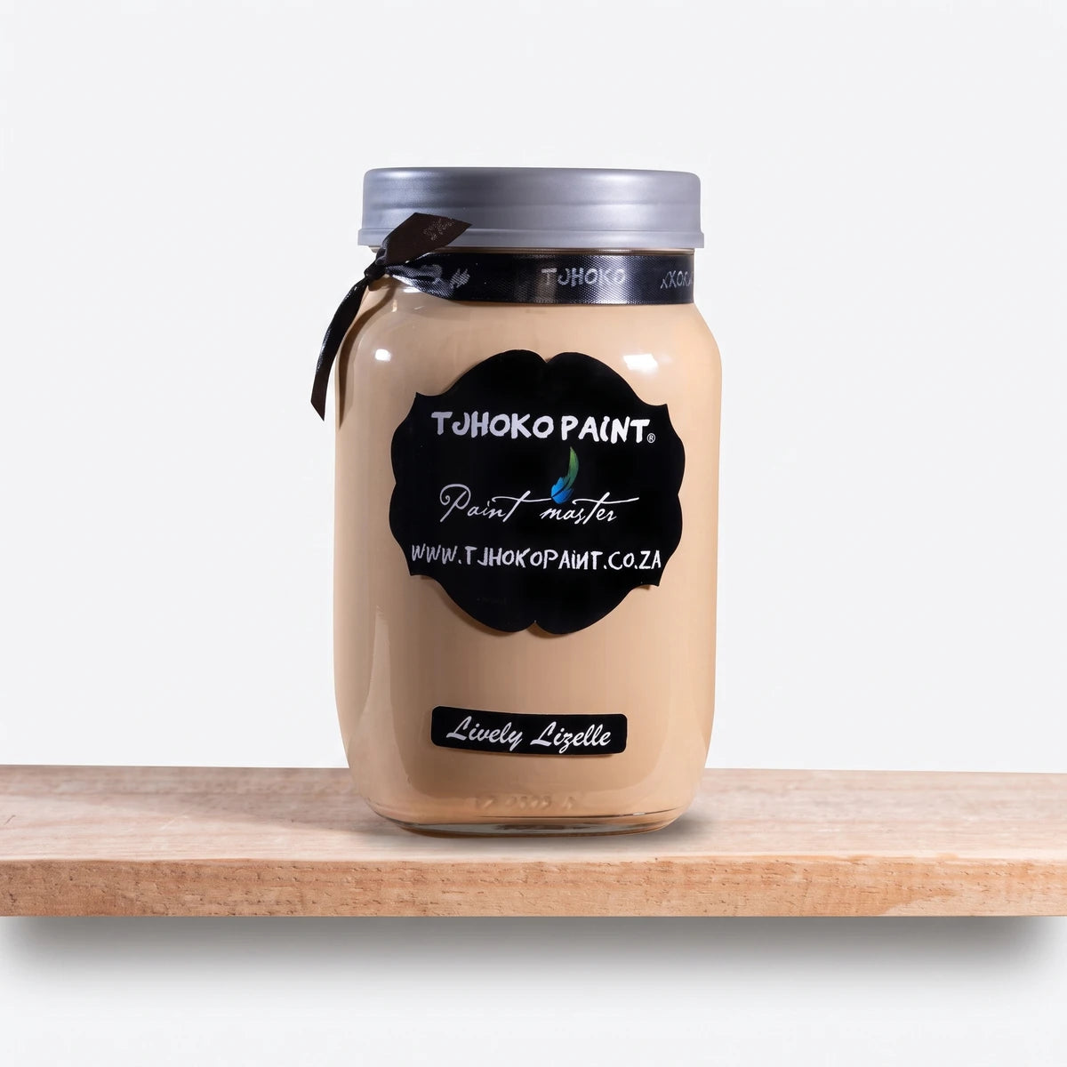 A 1L glass jar of Not Too Shabby Chalk Paint in 'Lively Lizelle' light beige, featuring a black label, silver lid, and a