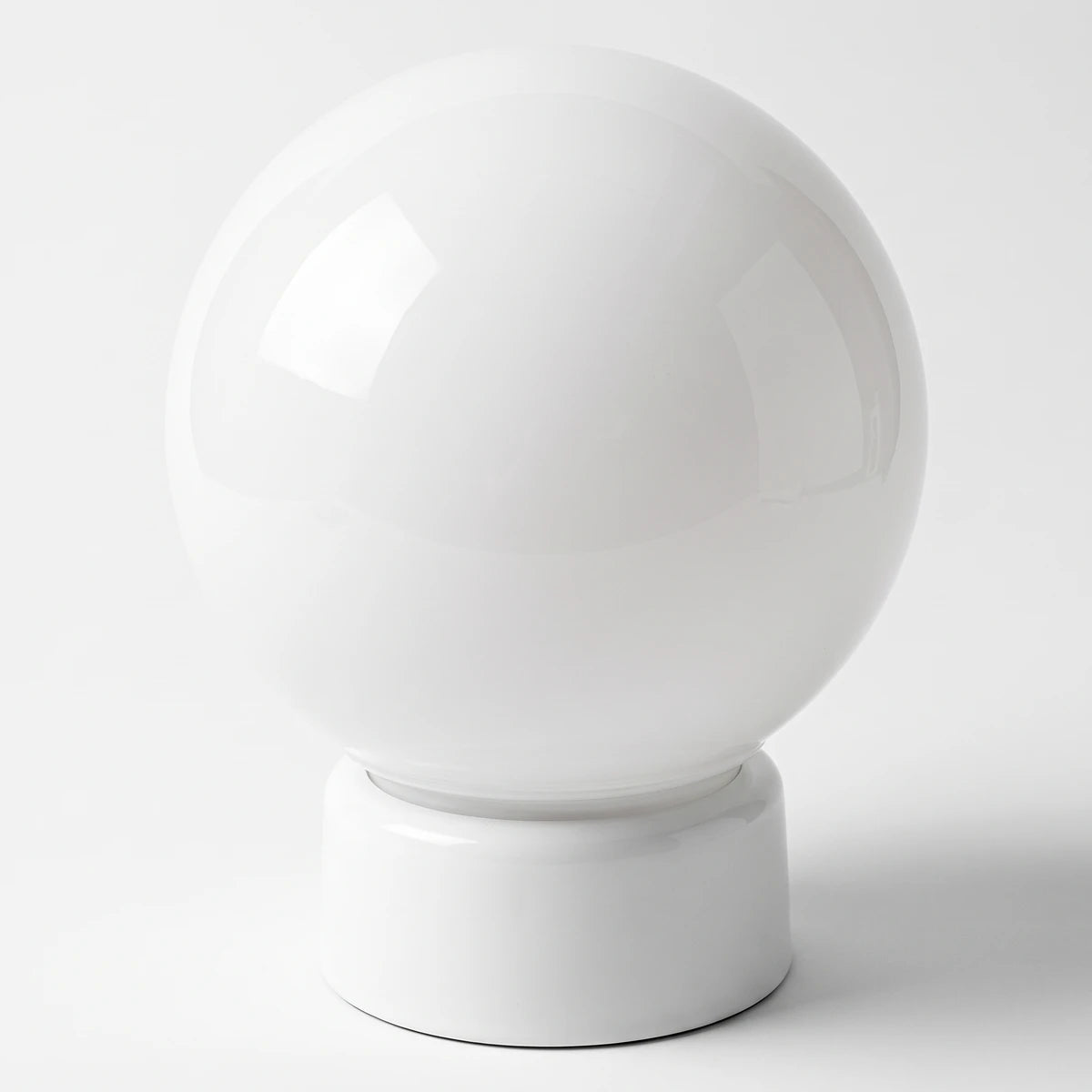 White glossy opal sphere with a gallery base, a Mr E light fixture, shown from a front-on view.