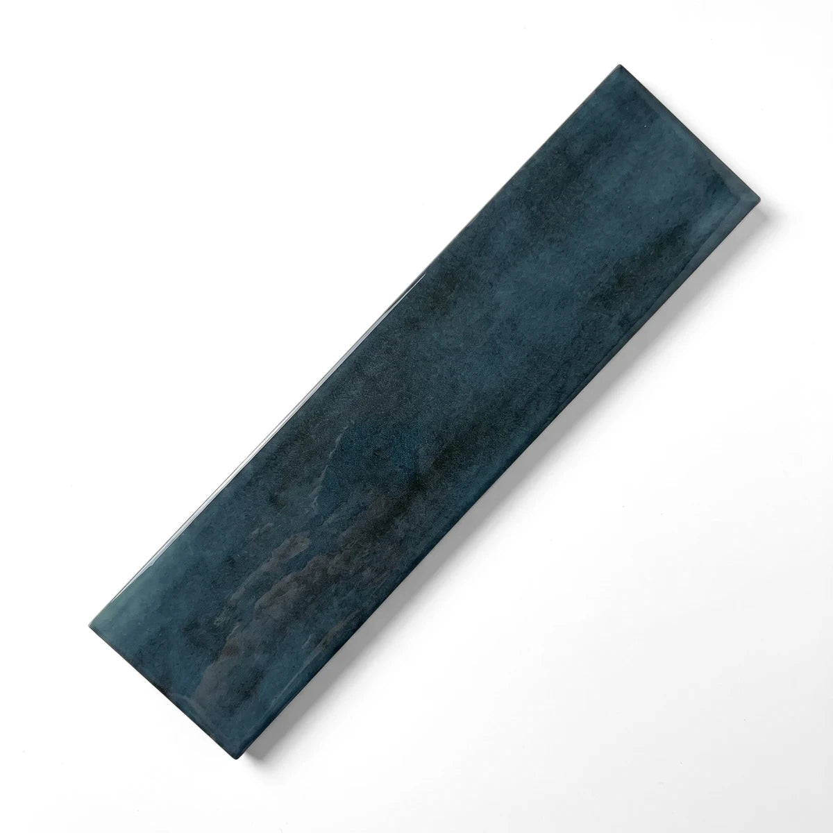 Peacock Blue Subway Tile, 75X300mm, featuring a glossy dark blue-green ceramic finish, displayed diagonally.