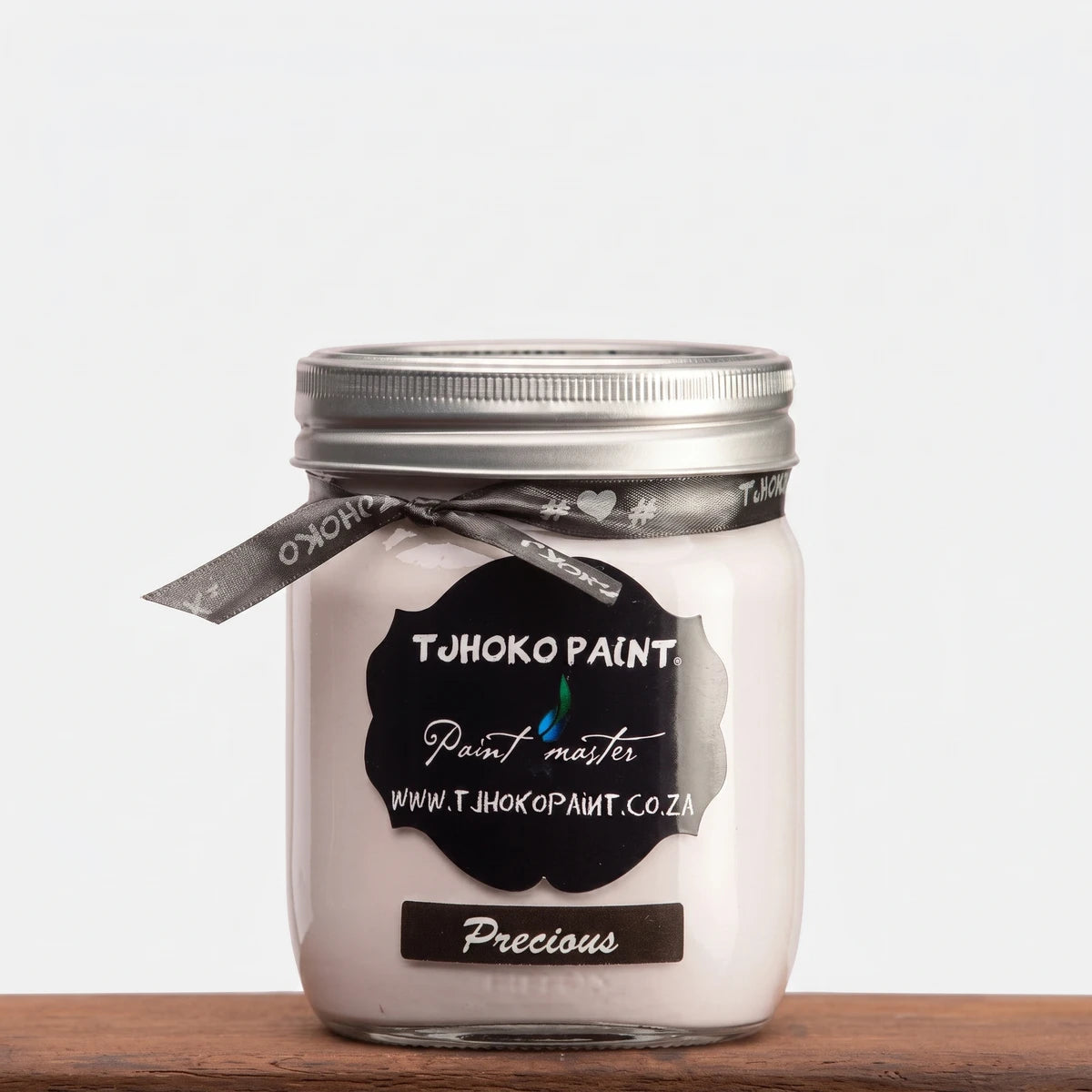 Precious 500ml TJOHOKO PAINT chalk paint in a clear glass jar with a silver lid, presented on a wooden surface.