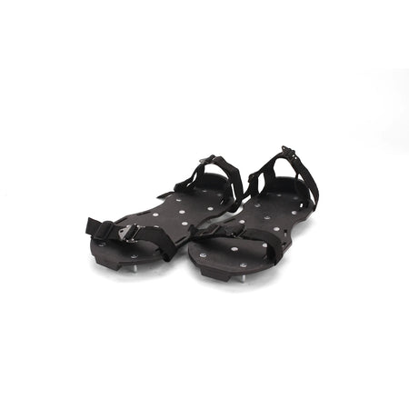 A pair of black Rox Spike Shoes with numerous silver spikes on the soles and adjustable black straps, offering enhanced