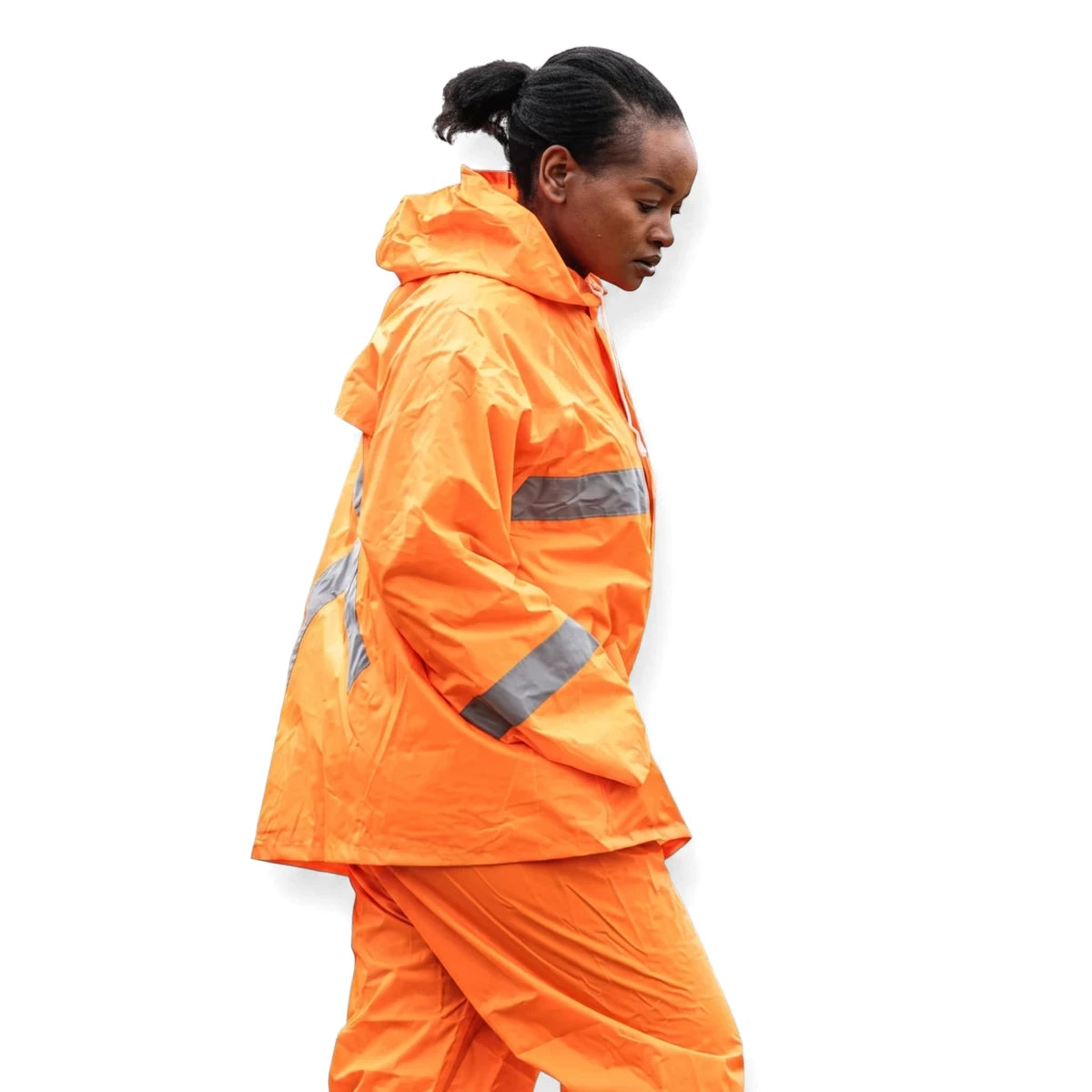 Woman in an orange rubberized hi-vis reflective rain suit, side profile looking down, industrial setting.