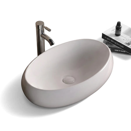 Ruby freestanding basin in white ceramic with an elegant oval shape, shown on a wood countertop with a chrome faucet.