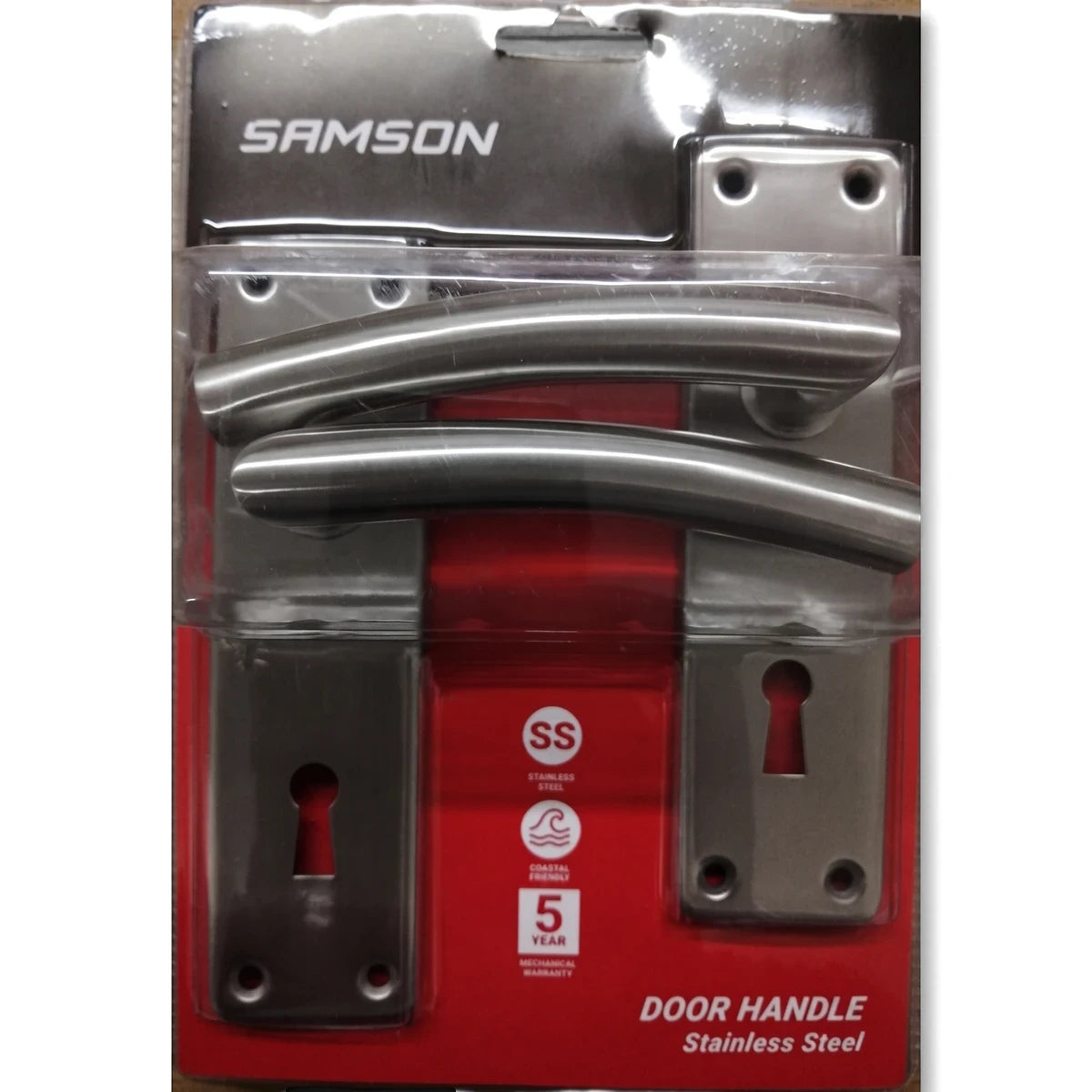 Samson stainless steel door handle set, featuring two curved handles and keyhole escutcheons, displayed in clear retail