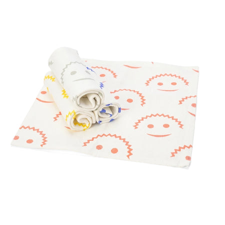 Three white Scrub Daddy Streakless Cloths with yellow, grey, and blue zigzag patterns, rolled and placed on a larger white