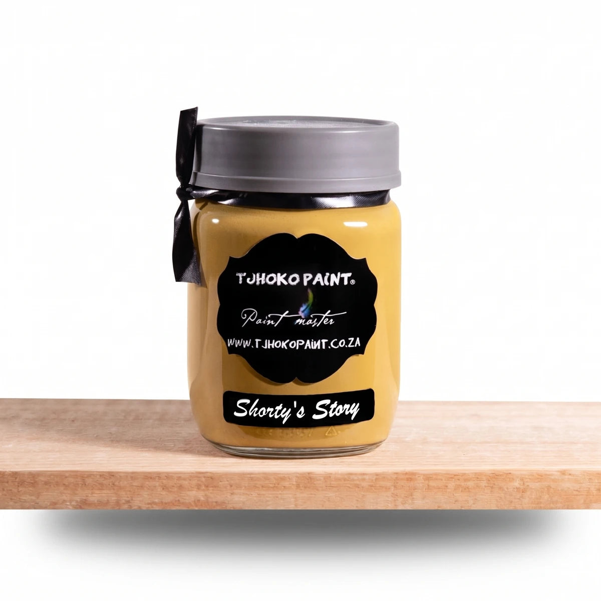 Shorty's Story 250ml Chalk Paint in a yellowish-gold glass jar, displayed on a natural wooden shelf.