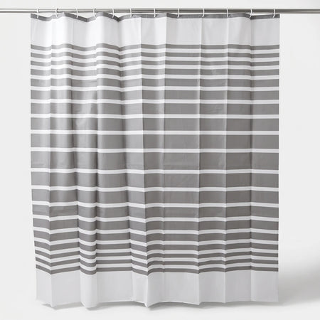 Grey and white striped shower curtain hanging on a rod, showcasing its full length and fabric texture.