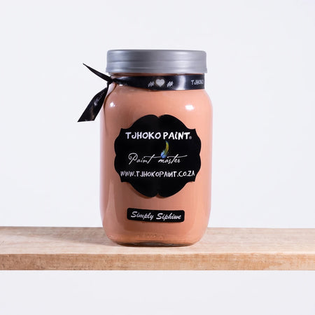Tjohoko Paint Simply Siphiwe 1L peach chalk paint in a clear glass jar with a grey lid and black ribbon, on a wooden shelf.