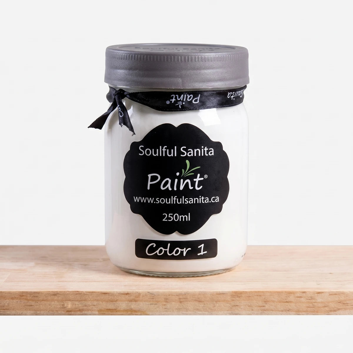 Soulful Sanita 250ml paint in a white jar with a dark gray lid and black label, positioned on a wooden shelf.