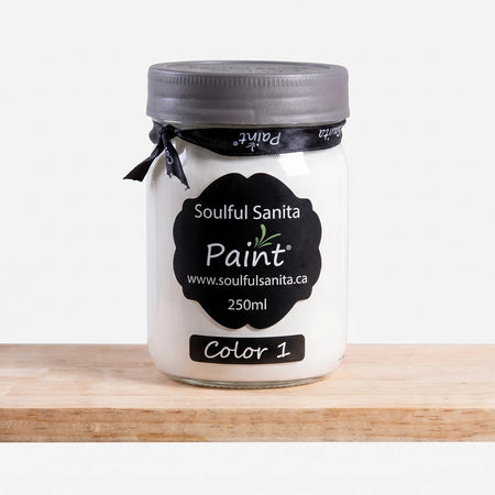 Soulful Sanita 250ml paint in a white jar with a dark gray lid and black label, positioned on a wooden shelf.