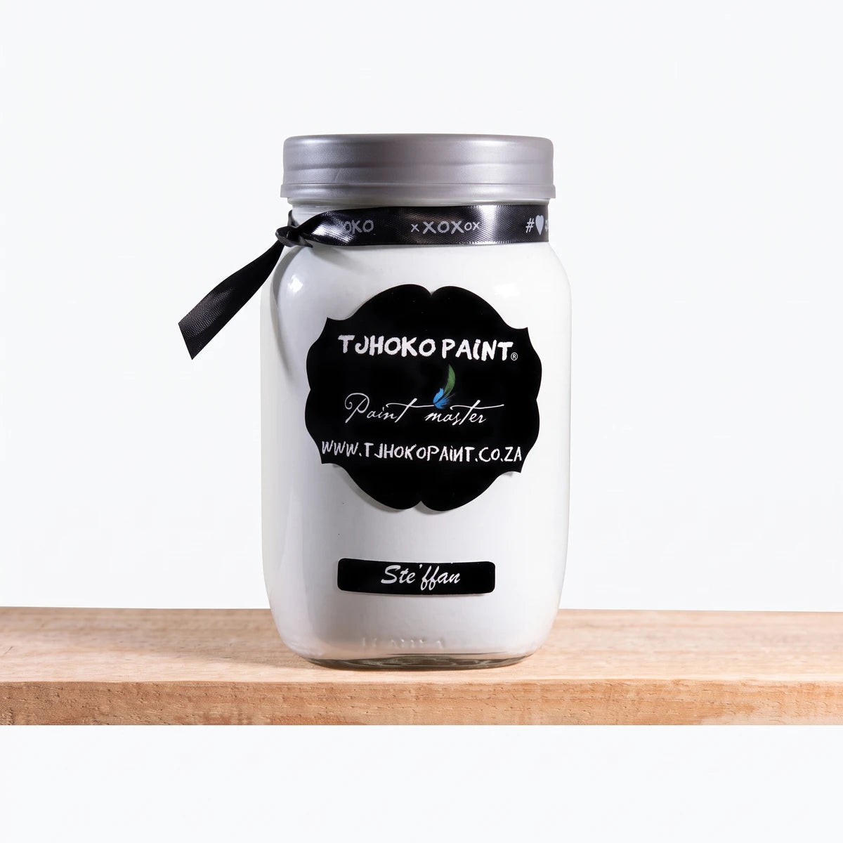 Stefann 1L Chalk Paint in a white glass jar with a black label and silver lid, resting on a wooden surface.