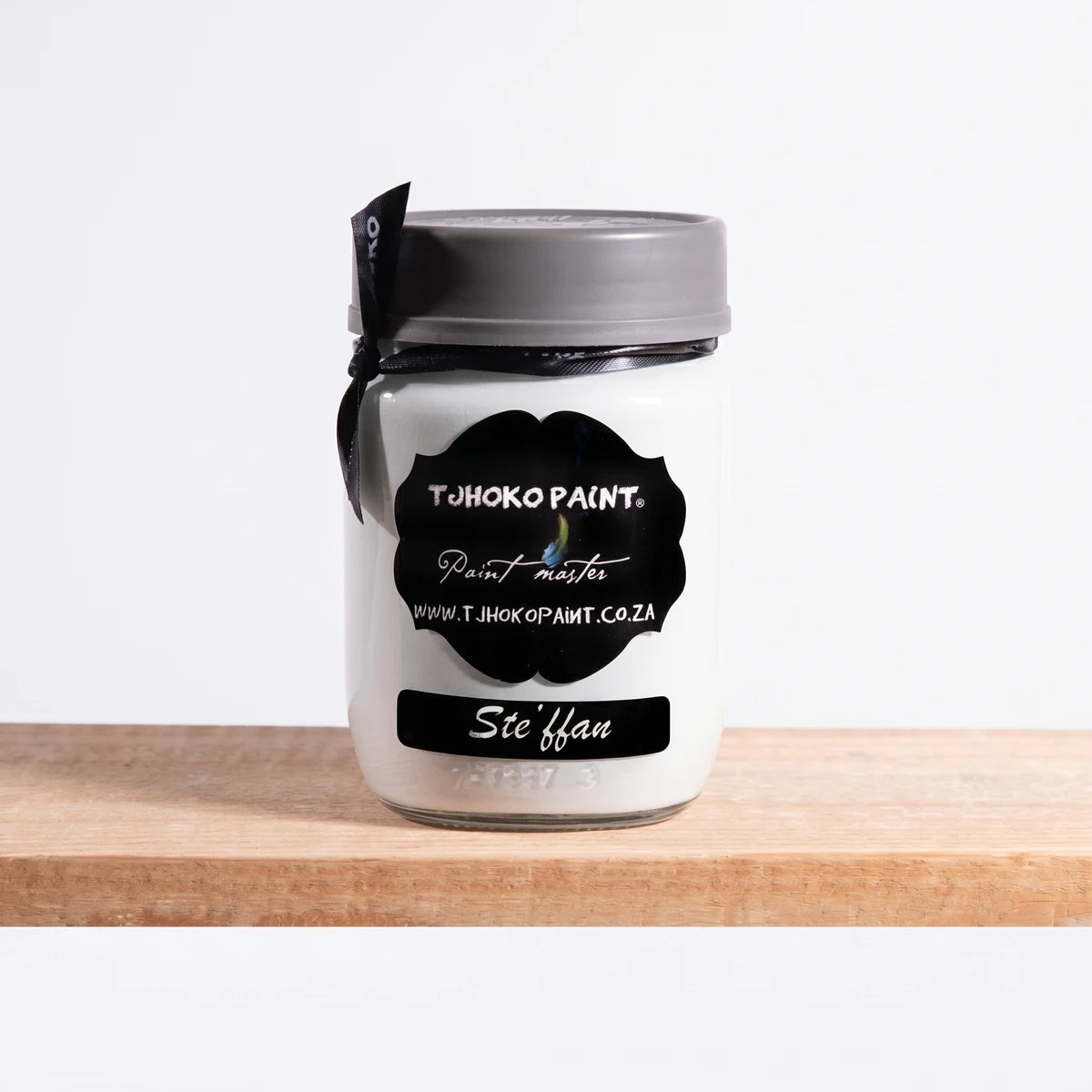 White Stefann 250ml Tjhoko Chalk Paint jar with a gray lid and black label, displayed on a natural wooden shelf.