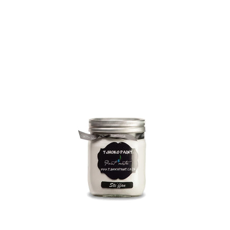 Stefann 500ml white chalk paint jar with a black label and grey ribbon, sitting on a natural wooden shelf.
