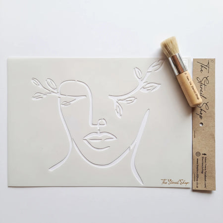 Sweet Elegance A4-23 Stencil 70, a white stencil with minimalist line art of a face and branches, next to a wooden stencil