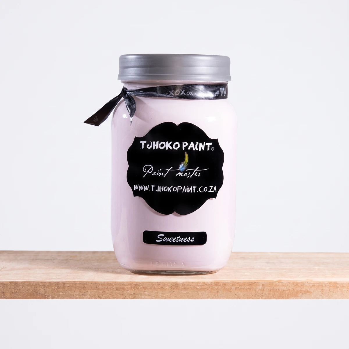 Sweetness 1L pale pink chalk paint in a clear glass jar with a silver lid and black label, sitting on a wooden shelf.