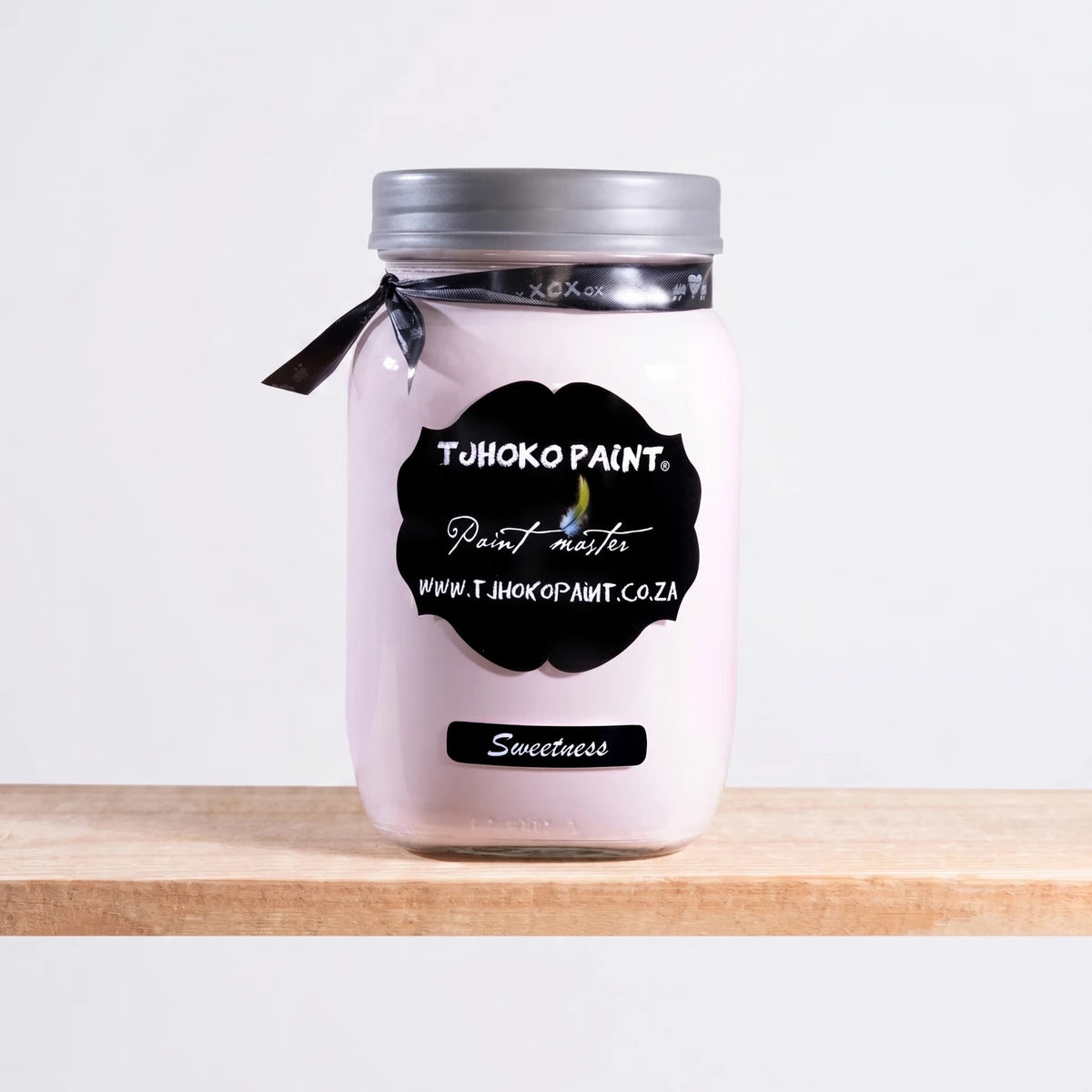 Sweetness 250ml Chalk Paint in a glass jar with a silver lid and black ribbon, displayed on a wooden shelf.