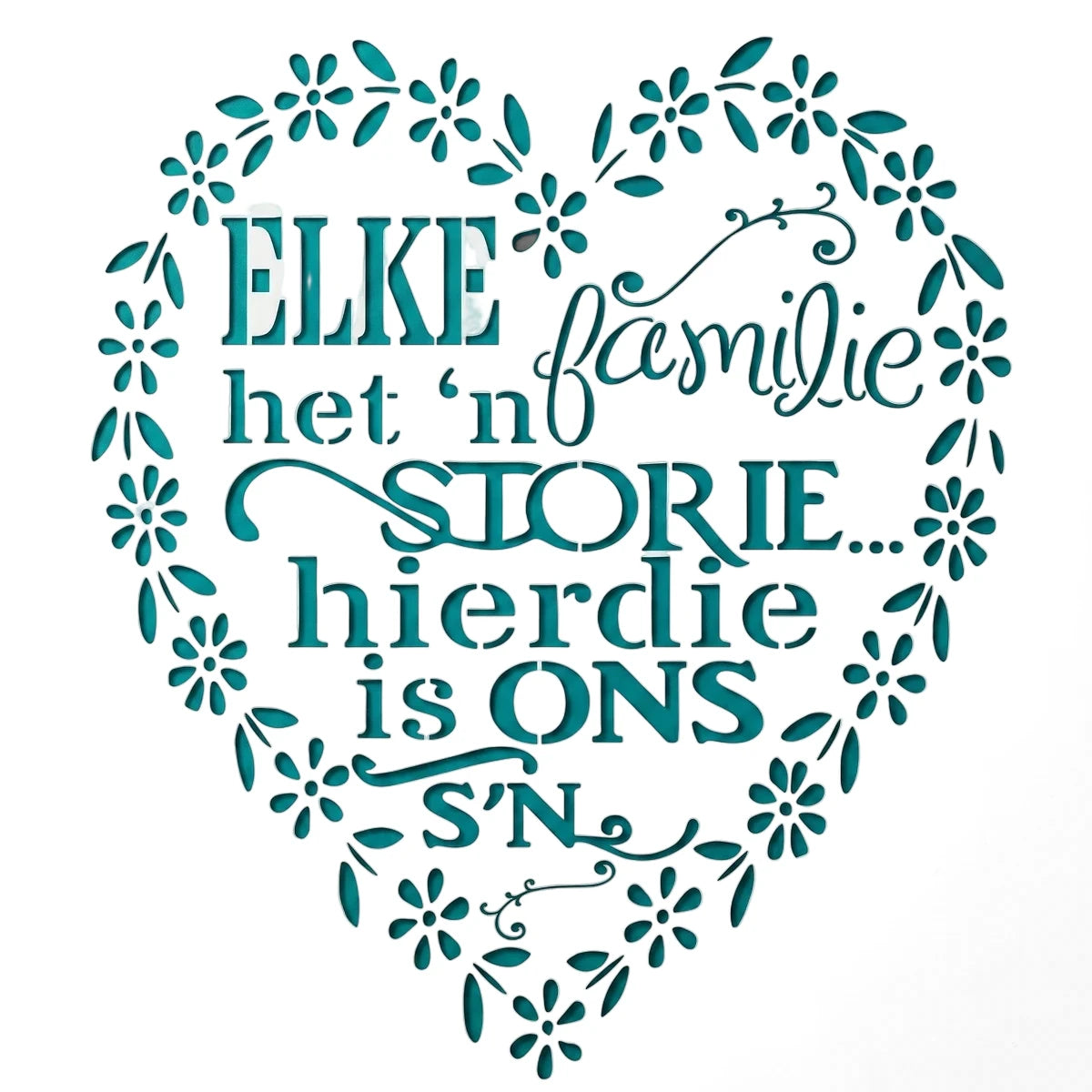 Tjhoko A4 Trans 25 Paint Stencil with an Afrikaans quote, 'ELKE familie het 'n STORIE hierdie is ONS S'N,' set within a teal