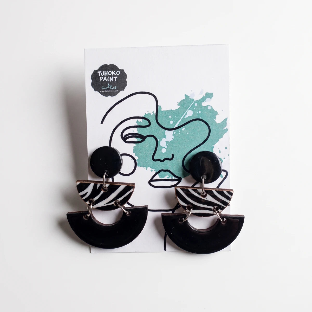 Tjhoko Matt Black Zebra Dangle Earrings with a round stud, striped semi-circle, and solid black base design.