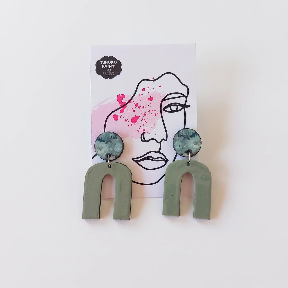 A pair of Tjhoko Olivia's Floral Art earrings featuring sage green arch shapes and circular floral print studs, displayed on