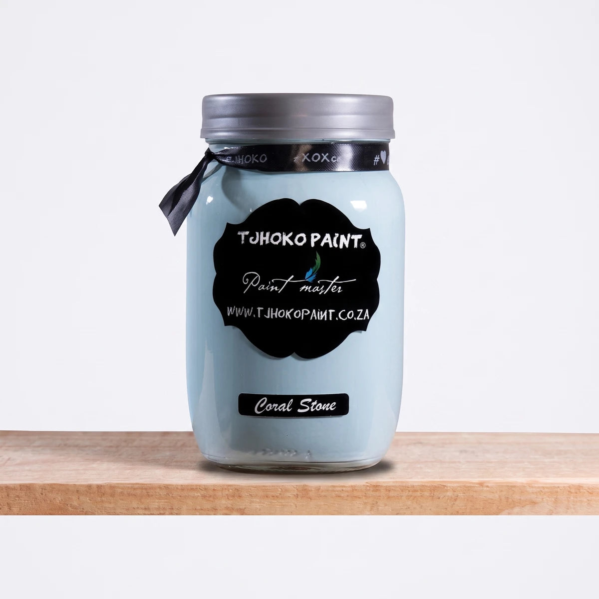 Coral Stone 1L Chalk Paint in a light blue glass jar with a silver lid and black label, displaying the Tjhoko Paint brand on