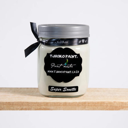 Tjhoko Paint Super Sonette 500ml chalk paint jar with a silver lid and black ribbon on a wooden shelf.
