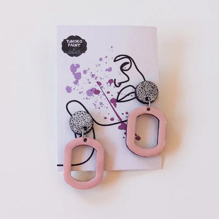 Tjhoko Sweetness Spots Earrings featuring light pink geometric shapes and speckled gray circular studs on a display card.