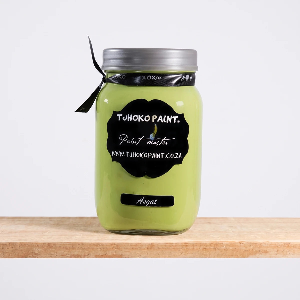 Tjohoko Paint 'Asgat' 1L chalk paint jar with a silver lid and black label, displayed on a wooden shelf.