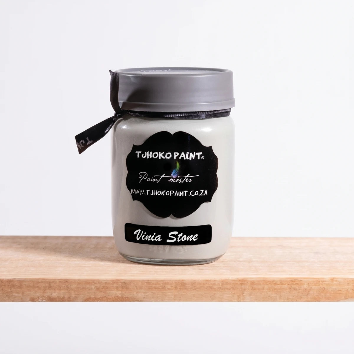 Vinia Stone 250ml Tjohoko Chalk Paint in an off-white jar, displayed on a natural wooden shelf.