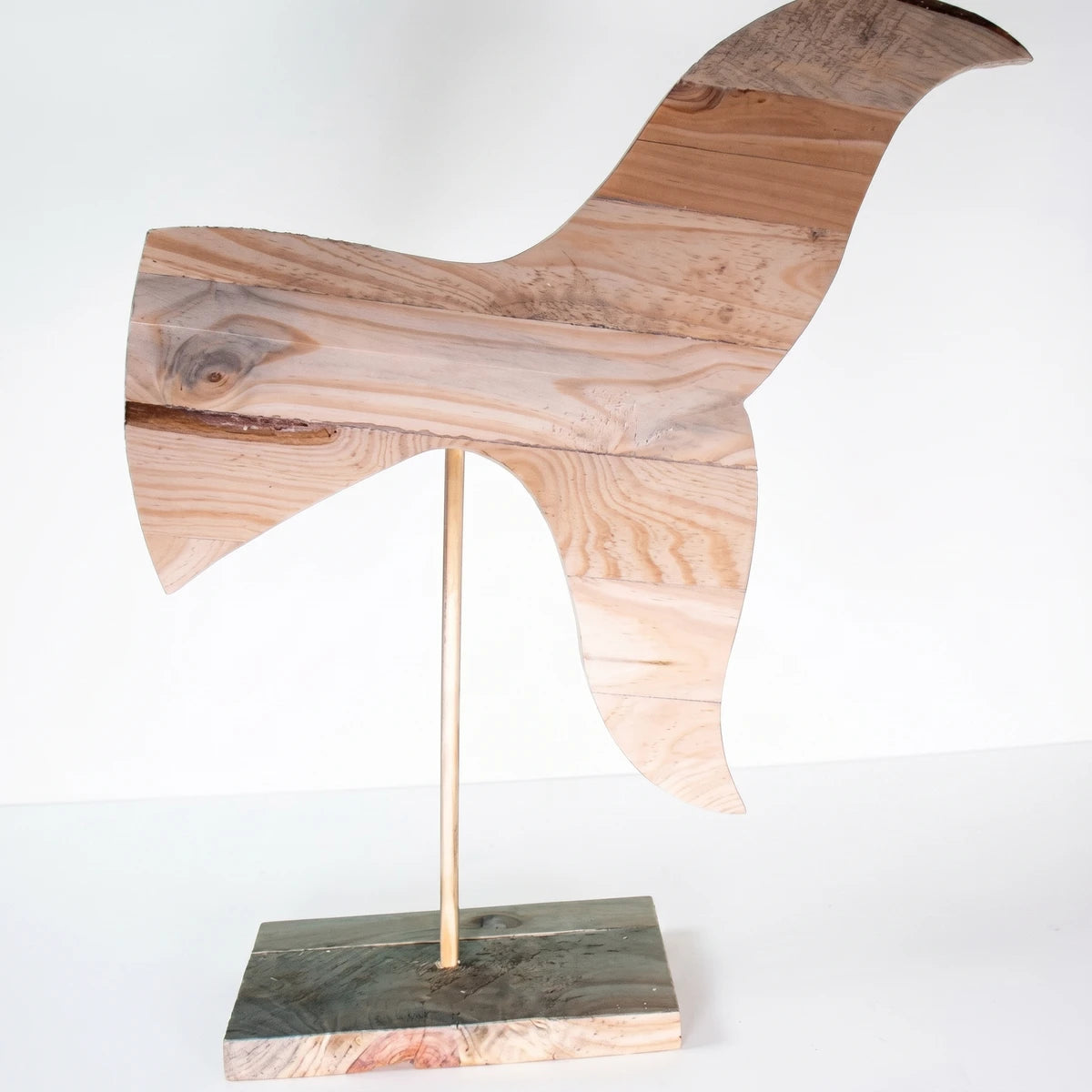 Large wooden whale tail sculpture on a stand, featuring natural raw wood planks and visible grain.