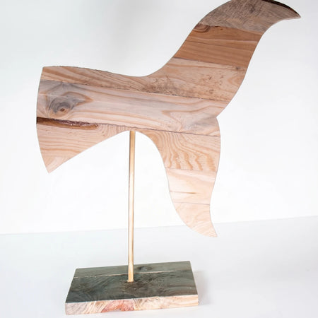 Large wooden whale tail sculpture on a stand, featuring natural raw wood planks and visible grain.