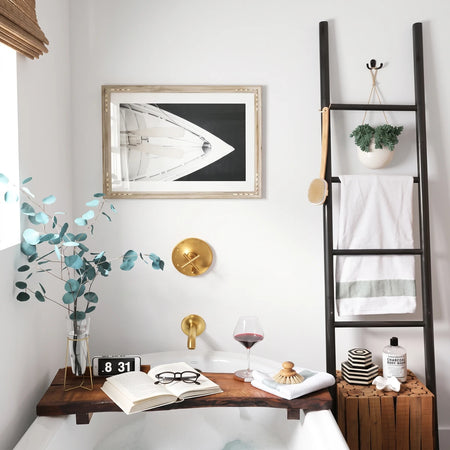 White Gloss Flat 10x30cm subway tiles in a modern bathroom featuring a bathtub with a wooden caddy and decorative elements.