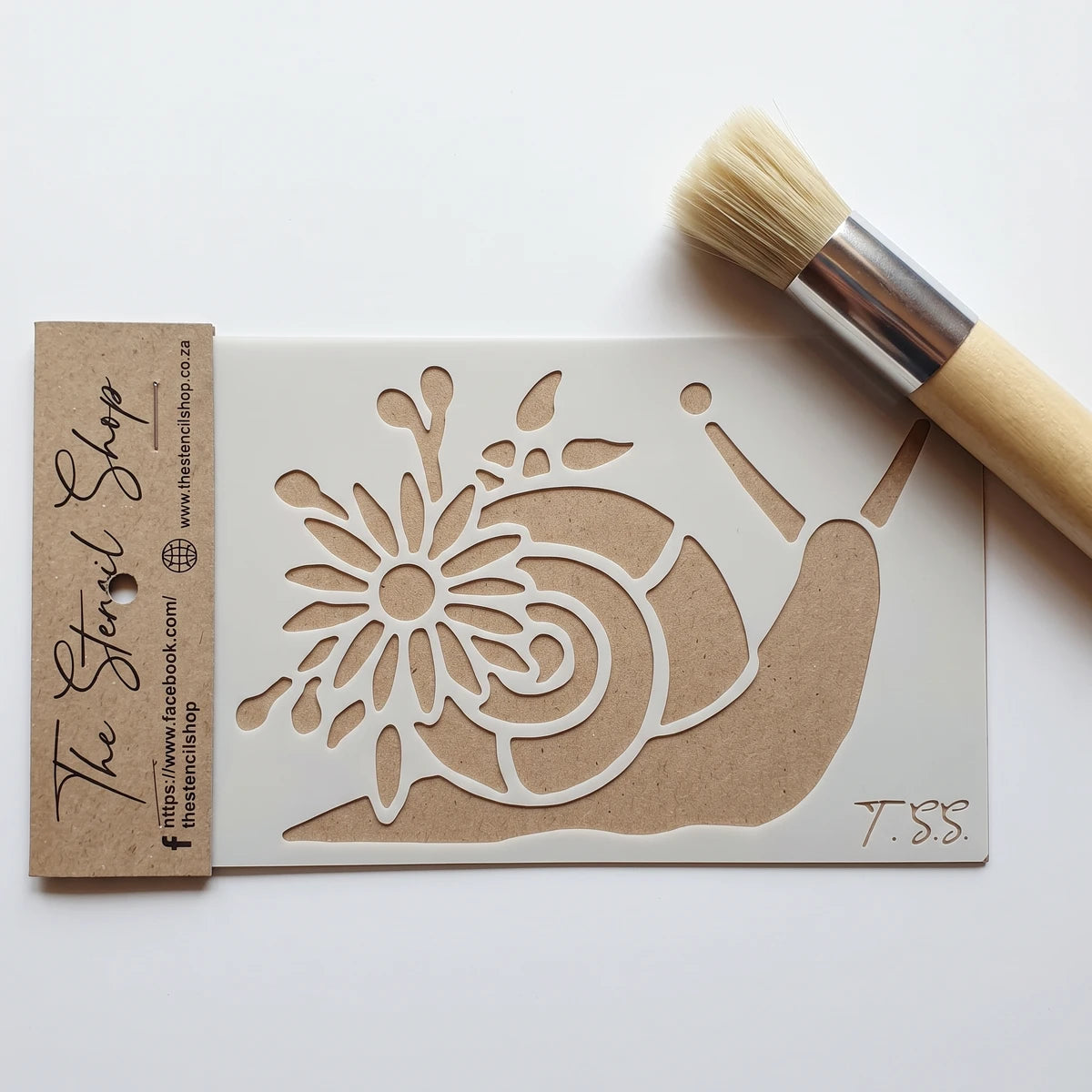 White plastic paint stencil featuring a snail and flower design, packaged with a brown header, shown next to a wooden handle
