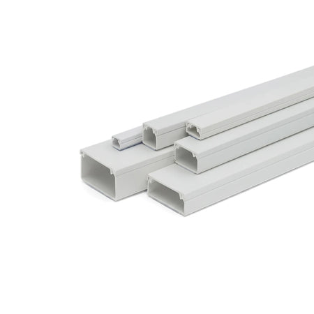 White PVC electrical trunking in various sizes, arranged diagonally on a white background, showcasing the open channels.