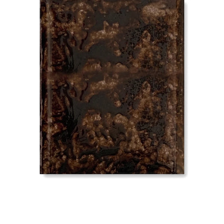 A close-up of a dark, textured square tile, likely a glazed black window cill, featuring an irregular, glossy surface