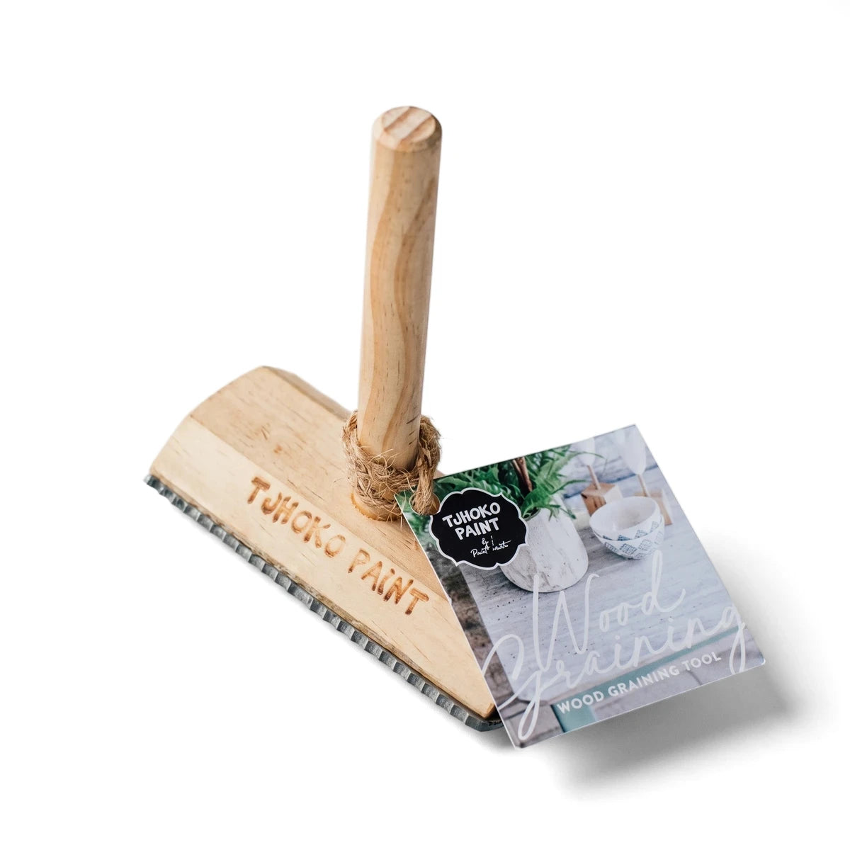 Natural wood grain tool with a rectangular base and cylindrical handle, featuring a branded hangtag, used for paint