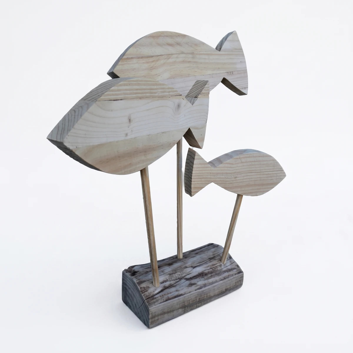 Decorative wooden fish sculpture on a stand, showcasing three light wood fish with natural grain on a rustic base.