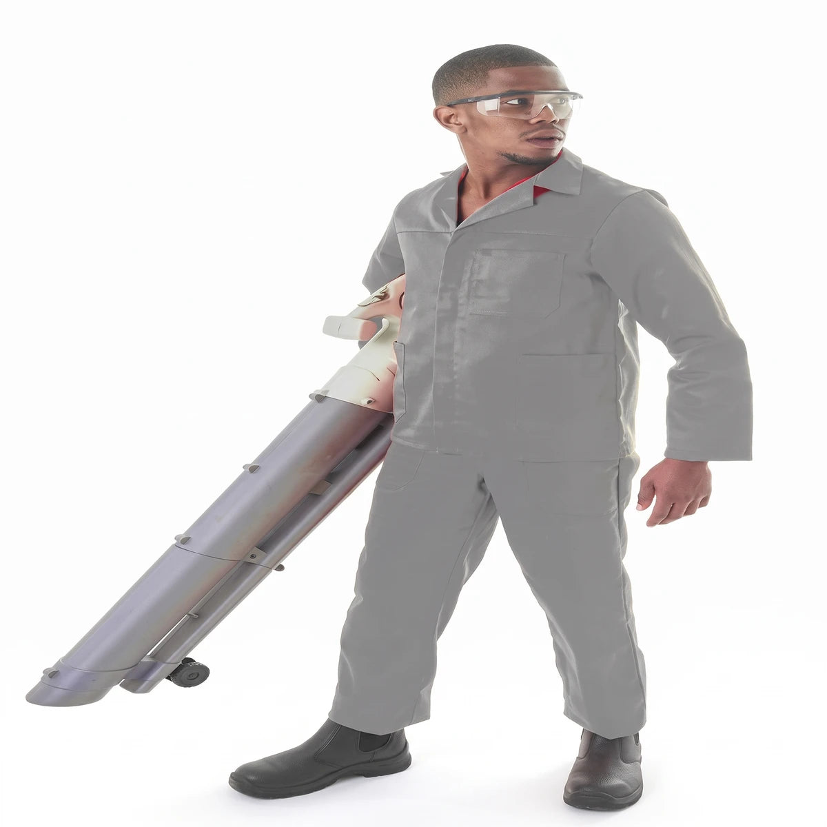 Young man wearing gray Conti Suit coveralls and clear safety glasses, holding a leaf blower, full body shot.